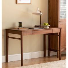 a wooden desk with a lamp on top of it in front of a mirror and window