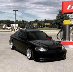 a black car parked in front of a gas station