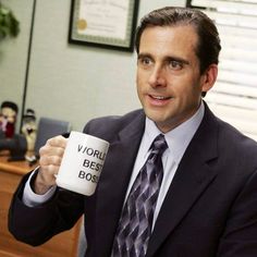 a man in a suit and tie holding a coffee mug with the words world best boss on it