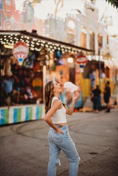 a woman standing in front of a carnival with her mouth open and looking up at the sky