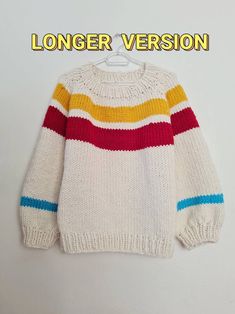 a white sweater with multicolored stripes hanging on a hanger and the words longer version above it