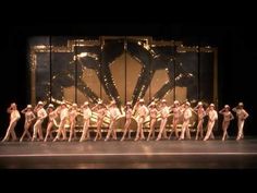 a group of dancers standing on top of a stage