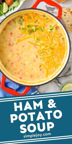 ham and potato soup in a red pot on a marble countertop with bread, vegetables, and cheese