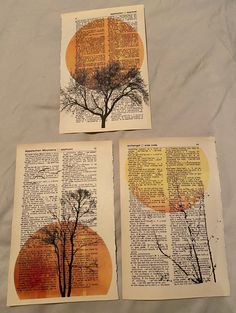 three pieces of art that are on top of an open book with trees in it