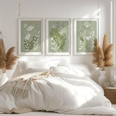 three framed pictures hang on the wall above a bed with white linens and pillows