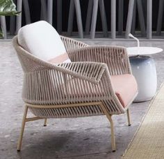 a wicker chair sitting on top of a floor next to a white coffee table