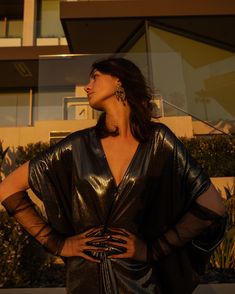 Indulge in the art of self-expression in this decadent metallic caftan. This exquisite garment is more than just a piece of clothing; it's a celebration of fabric in all its glory. Crafted with generous amounts of a slinky black jersey coated in a gorgeous mercurial foil and lots of love, this piece offers an airy fit designed to drape beautifully on all body types. Whether worn over a swimsuit for a day at the beach or layered and adorned with your favorite accessories for a glamorous evening a Gold V-neck Kaftan For Party, Gold Kaftan For Party And Festive Occasions, Elegant Dresses With Kimono Sleeves For Festivals, Festive Silver Dress For Celebration, Festive Silver Celebration Dress, Festive Dress With Kimono Sleeves, Glamorous Festive Evening Kaftan, Evening Kaftan With Kimono Sleeves, Stocking Fillers For Her