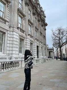 a woman standing in front of a large building