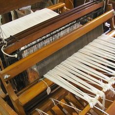 an old weaving machine with white yarn on it