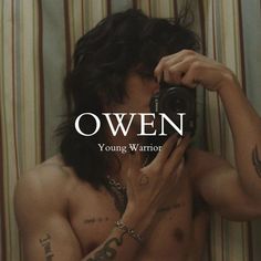 a shirtless man taking a selfie in front of a striped wall with the words own on it