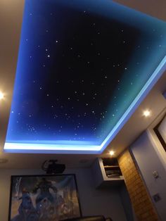 the ceiling is lit up with blue lights and stars in the night sky above it