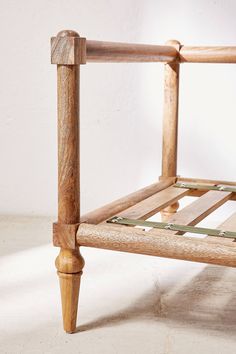 a wooden bed frame sitting on top of a white floor