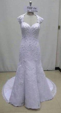 a white wedding dress on display in a room