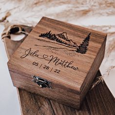 a wooden box with a couple's initials on it sitting on top of a table