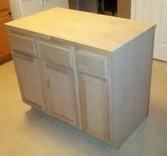 a kitchen island made out of wood in the middle of a room