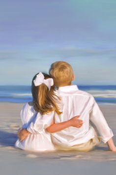 two children are sitting on the beach and one is holding another child's back