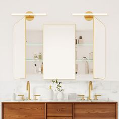 a bathroom vanity with two mirrors and gold faucets