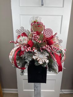 a christmas wreath with candy canes and candies on it in front of a door