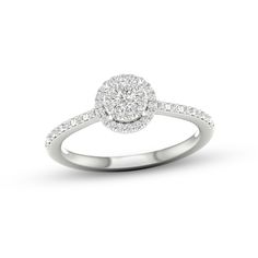 a white gold ring with diamonds on the band and an oval shaped center stone in the middle