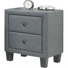 a small grey nightstand with a clock on it's top and two drawers below