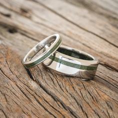 two wedding rings sitting on top of a wooden table