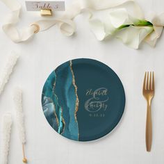 a table setting with place cards, forks and napkins on top of the plate