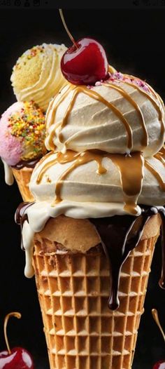 an ice cream sundae with cherries and whipped cream on top, in a waffle cone