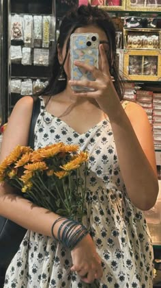 a woman taking a selfie while holding flowers