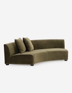 the corner sofa has two pillows on it and is made out of suede fabric