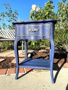 a small blue table sitting on top of a sidewalk