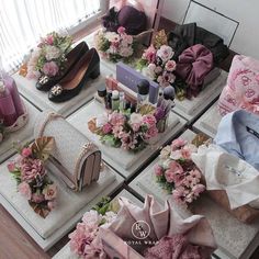 a table topped with lots of different types of bags and purses covered in flowers