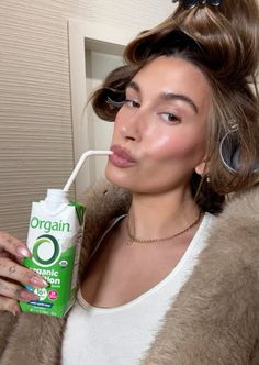 a woman holding a tube of toothpaste in her hand and looking at the camera