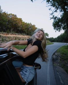 a woman leaning out the window of a car