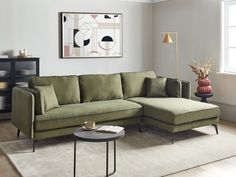 a living room with a sectional couch and coffee table in front of a painting on the wall