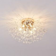 a chandelier hanging from the ceiling in a room with white walls and flooring