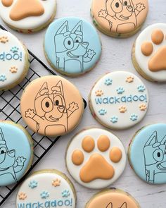 decorated cookies with cartoon characters on them sitting on a cooling rack next to other cookies