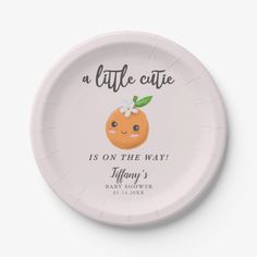 a little cute plate with an orange on the front and green leaves on the back