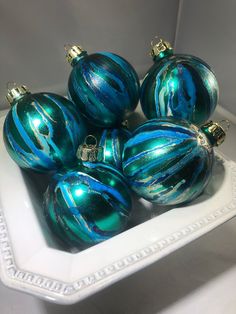 blue and green ornaments in a white bowl