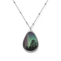 "Stunning and unique one-of-a-kind Aurora Borealis oval nature inspired necklace features a nature photography print of The Northern Lights. The unique nature photography silver pendant and its longer length adjustable specialty chain are made with a robust zinc-alloy blend for a dazzling look and feel. The pendant, shaped in the form of an ellipse and the 20\" adjustable silver chain is embellished with beading and a lobster clasp closure. Pendant art features an original Northern Lights photography print with a beautiful glossy finish.  Makes a thoughtful gift for a photography or nature lover.  Pendant height: 1.5 inches Pendant width: 1 inch Chain length: 20.47 inches" Nature-inspired Necklace With Large Oval Pendant, Nature-inspired Engraved Oval Pendant Necklaces, Nature-inspired Engraved Oval Pendant Necklace, Nature-inspired Oval Engraved Necklaces, Nature-inspired Oval Engraved Necklace, Nature-inspired Oval Jewelry With Large Pendant, Silver Nature-inspired Teardrop Pendant Necklace, Silver Teardrop Pendant Necklace Nature-inspired, Sterling Silver Oval Necklace With Nature-inspired Style