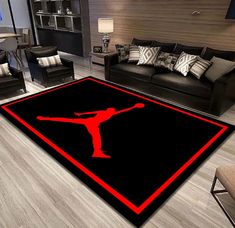 a living room area rug with a red and black design on the floor in front of a couch