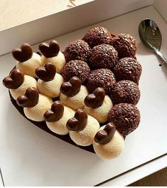 a heart shaped box filled with lots of chocolate covered cookies and marshmallows