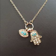 Introducing our Women's Fashion Jewelry Silver or Gold Plated Evil Eye Hamsa Hand Necklace, a stylish and symbolic accessory that combines the protective powers of the Evil Eye and the Hamsa Hand. The pendant of this necklace features a beautifully designed Hamsa Hand, a traditional symbol known for its protective qualities and ability to ward off negative energies. The Hamsa Hand is believed to bring luck, happiness, and blessings to the wearer. At the center of the Hamsa Hand pendant is the Evil Eye, a symbol used for centuries to protect against malevolent forces and to ward off negative influences. The Evil Eye is said to watch over the wearer, deflecting negative energy and bringing good fortune and protection. This necklace is available in either silver or gold plating, allowing you Symbolic Pendant Necklace With Lobster Clasp, Evil Eye Symbolic Metal Jewelry, Spiritual Metal Evil Eye Necklace, Symbolic Evil Eye Metal Jewelry, Spiritual Evil Eye Metal Necklace, Spiritual Metal Necklaces With Charms, Gold Symbolic Evil Eye Charm Necklaces, Symbolic Gold Evil Eye Charm Necklaces, Spiritual Metal Charm Necklaces With Adjustable Chain