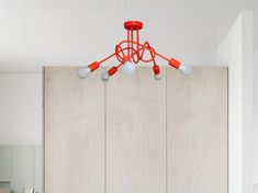 an orange chandelier hangs from the ceiling in a white room with wood paneling