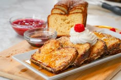 french toast with whipped cream and raspberry toppings on a plate next to a loaf of bread