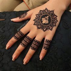 a woman's hand with henna tattoos on it