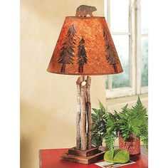 a lamp that is sitting on top of a table next to a potted plant