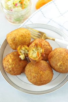 some food is sitting on a plate with a fork and glass bowl in the background