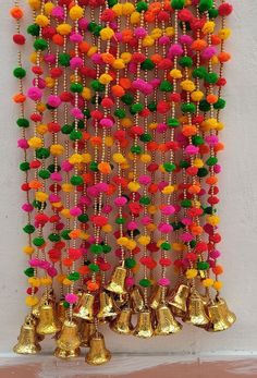 a colorful wall hanging with bells and tassels