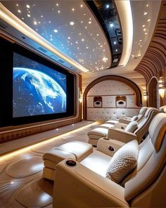 a home theater with white leather seats and a large screen on the wall above it