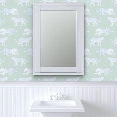 a white sink sitting under a bathroom mirror next to a wall mounted faucet